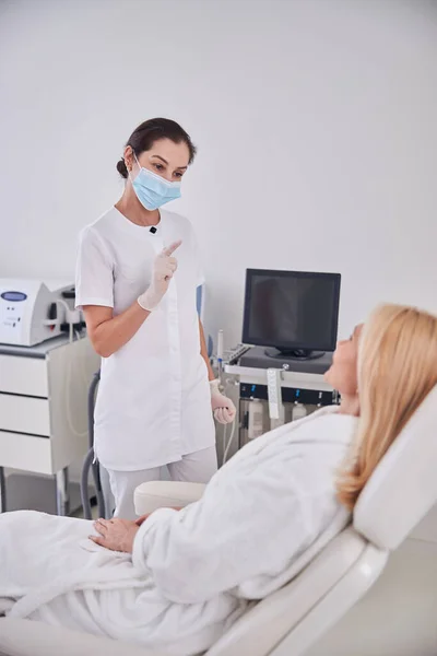 Elegante médico profesional que habla con el paciente en el centro de spa de belleza — Foto de Stock