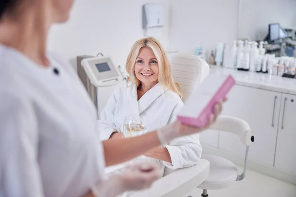 Pretty lady in white clothes looking to her doctor in cabinet — Stock Photo, Image