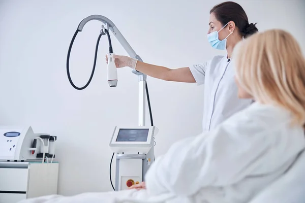 Esteticista demostrando nueva máquina de ultrasonido para peeling facial — Foto de Stock