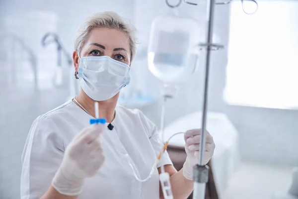 Enfermera profesional adulta demostrando perfusión IV en la cámara en la clínica de medicina —  Fotos de Stock