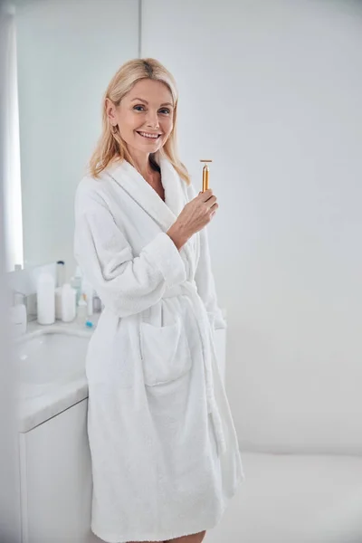Красивая элегантная женщина выглядит и позирует перед фотокамерой в ванной комнате — стоковое фото