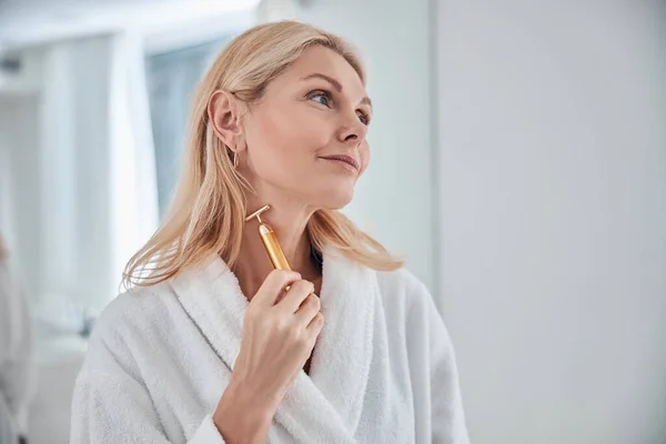 Schöne Frau posiert vor der Fotokamera im Badezimmer mit Massagegerät — Stockfoto