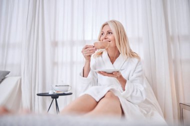 Mutlu gülümseyen güzel bayan spa tatil köyünde harika vakit geçiriyor.