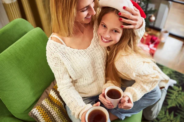 Ragazza felice che celebra il Natale con la madre premurosa al chiuso — Foto Stock