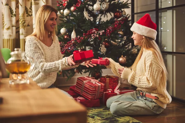 Happy girl unwrapping presents with mom at Christmas — Stock Photo, Image