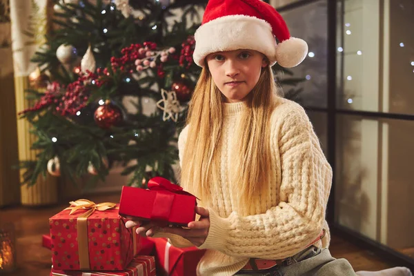 Curious cute girl with Christmas present indoors — Stock Photo, Image