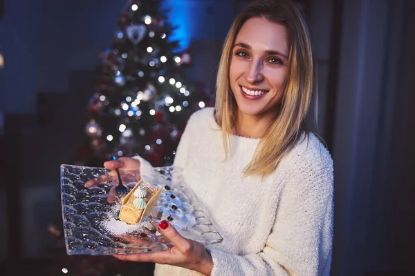 Smiling beautiful woman having cake at Christmas — Stock Photo, Image