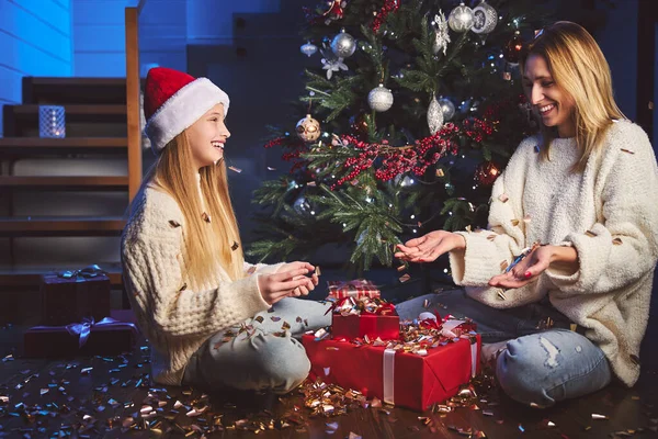 Cheerful woman and girl celebrating Christmas at home — Stock Photo, Image
