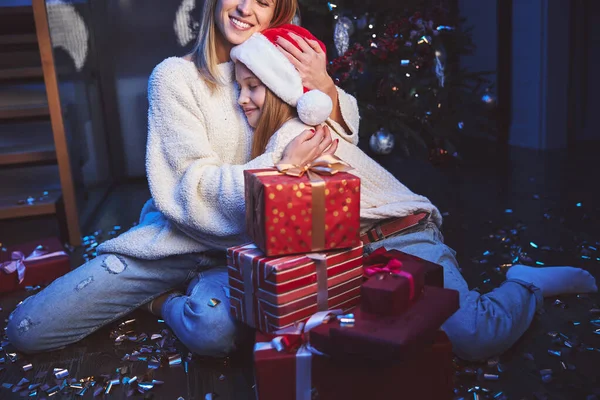 Mãe carinhosa abraçando filha perto da árvore de Ano Novo — Fotografia de Stock