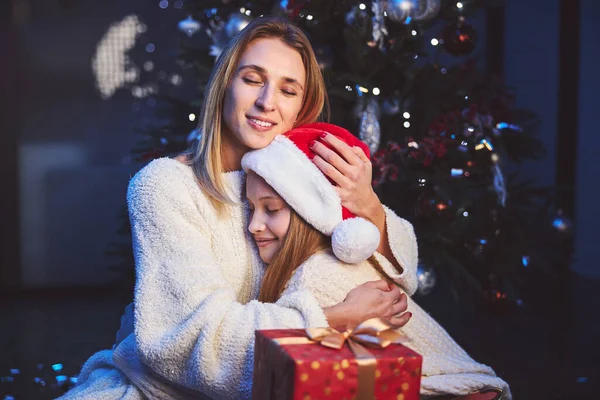 Szczęśliwa matka przytula ukochaną córkę na Boże Narodzenie — Zdjęcie stockowe