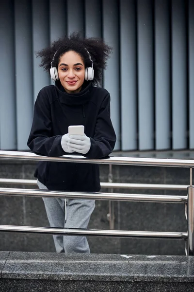 Piacevole riposo femminile con telefono vicino alla ringhiera — Foto Stock