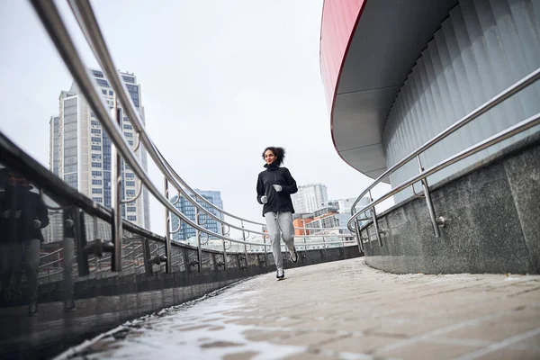 Ivrig idrottsman gör sin morgon springa på en inhägnad väg — Stockfoto
