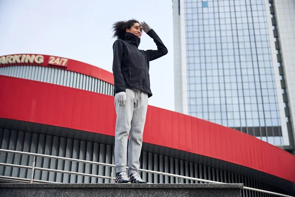 Mujer de pie recta y protegiendo sus ojos con una palma —  Fotos de Stock