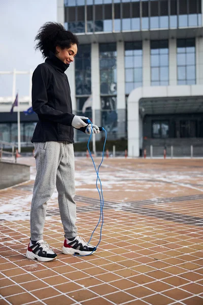 Content vrouw kijken naar een touw onder haar sneaker — Stockfoto