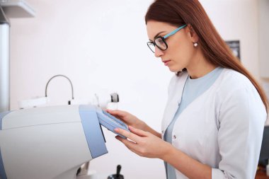 Gözlüklü tıbbi kişi aygıt ayarlarını kontrol ediyor