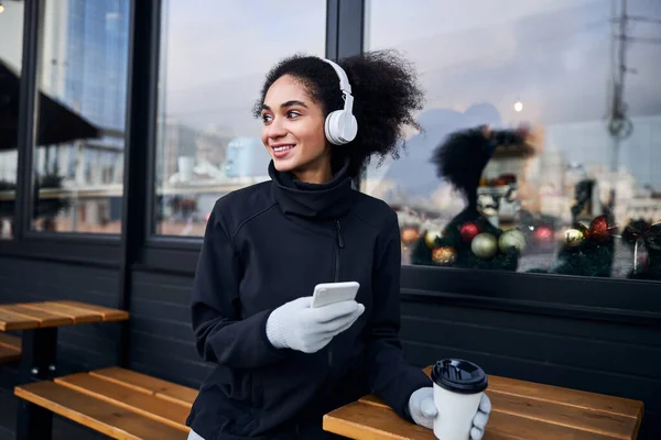 Adulto in un caffè girando la testa dal display del telefono — Foto Stock