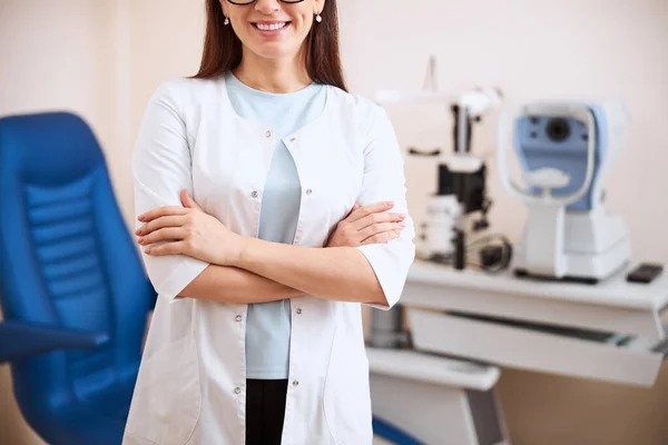 Medic vouwt haar handen naast een oogonderzoek apparatuur — Stockfoto