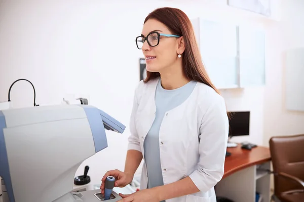 Profissional médico usando joystick de um autorefrator — Fotografia de Stock