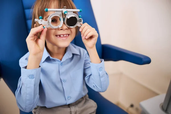 Niño feliz girando las palancas de gafas de ensayo — Foto de Stock