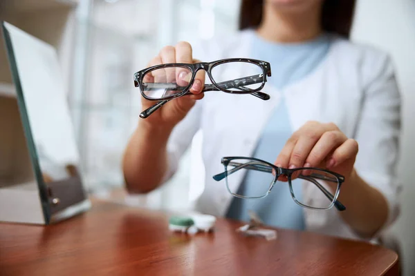 Läkare som tillhandahåller två varianter av glasögon — Stockfoto