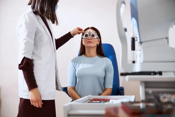 Ögonläkare som gör en horisontell justering av en försöksram — Stockfoto