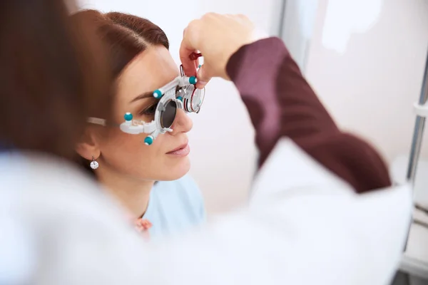 Pessoa médica colocando uma lente dentro de um quadro experimental — Fotografia de Stock
