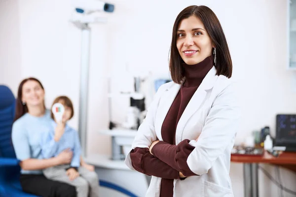 Satisfied doctor in a white coat looking proudly at camera — Stock Photo, Image