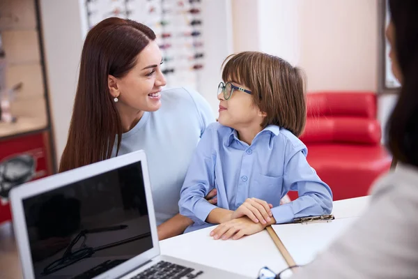 Ragazzo scambiare sguardi con sua madre mentre indossa occhiali — Foto Stock