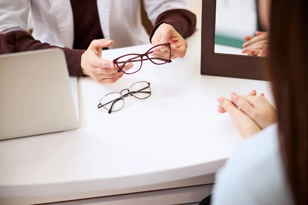 Händerna på en medicinsk person som håller glasögonen — Stockfoto