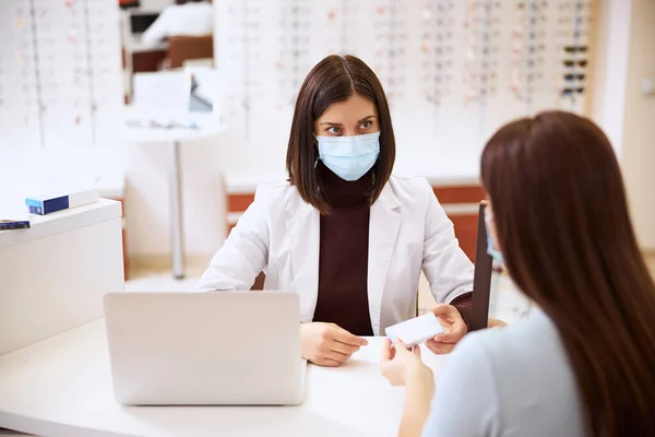 Trabajador médico cauteloso propone una caja de lentes a una mujer — Foto de Stock