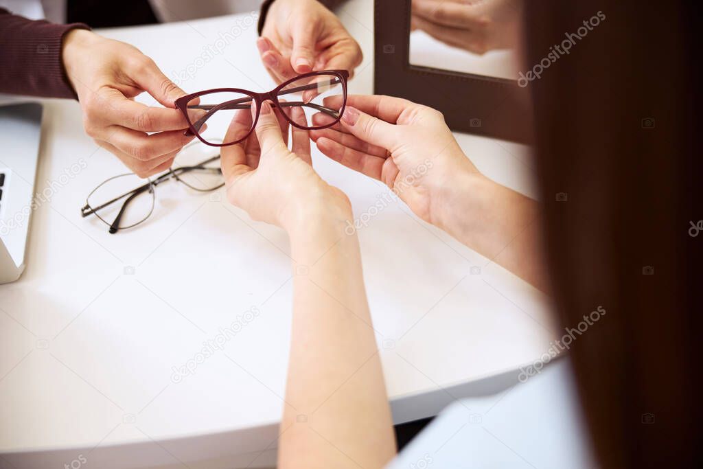 Person taking away the spectacles from physician hands