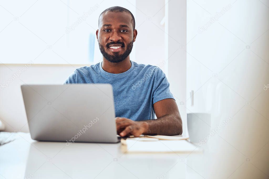 Mixed-race worker enjoying his work on a laptop