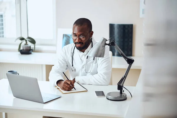 Ιατρικός ειδικός κάθεται μπροστά από έναν υπολογιστή — Φωτογραφία Αρχείου