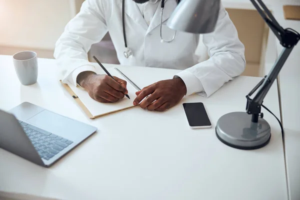 Händerna på en läkare som håller i en penna — Stockfoto