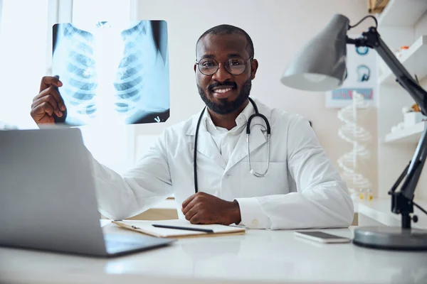 Satisfecho terapeuta está mostrando una radiografía — Foto de Stock