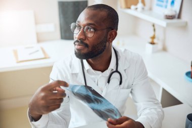 Doktor ofisindeki bir şeye dikkat ediyor.