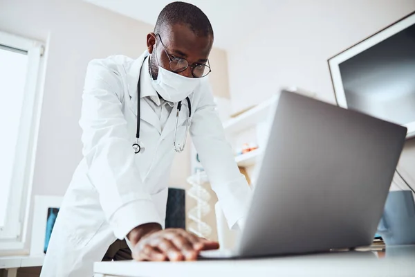 Pessoa médica em pé diante de uma tela de laptop — Fotografia de Stock