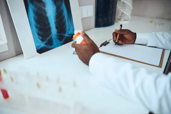 Man framför en röntgenbild med anteckningar om medicin — Stockfoto