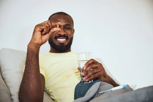 Oranje pil in de hand van een multi-etnische man — Stockfoto