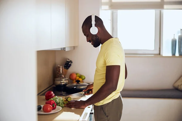 Cozinhe ouvindo música enquanto prepara comida — Fotografia de Stock