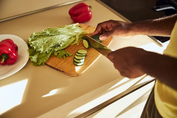 Взрослый мужчина режет зеленый овощ — стоковое фото