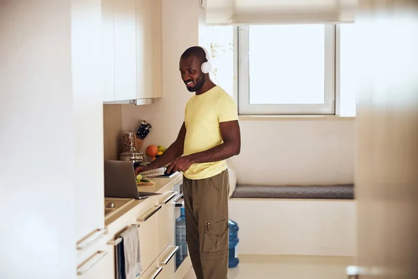 Cocinero multiracial viendo una película en el portátil mientras cocina —  Fotos de Stock