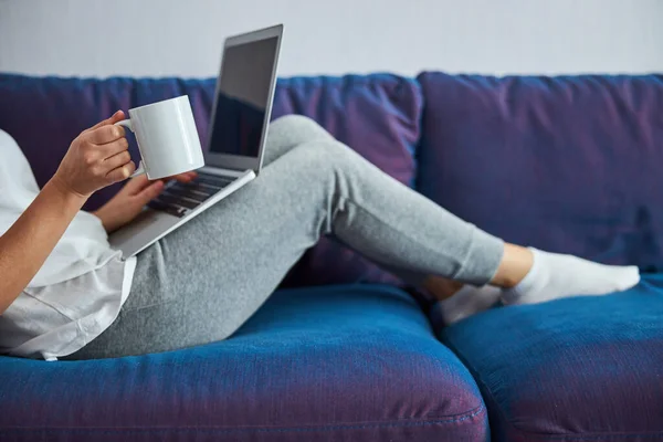Kvinna med laptop dricka te hemma — Stockfoto