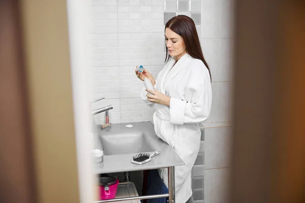 Femme gaie prenant soin de la peau dans la salle de bain — Photo