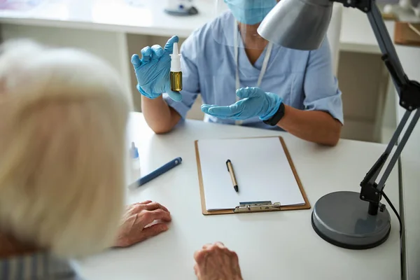 Terapeut gör en nässpray demonstration — Stockfoto