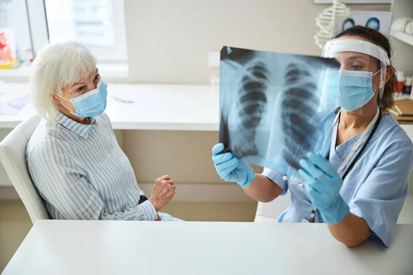女医生与病人一起研究X射线图 — 图库照片