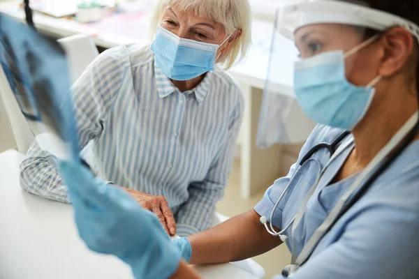 Fröhliche Rentnerin hört gute Nachrichten über ihr Röntgenbild — Stockfoto