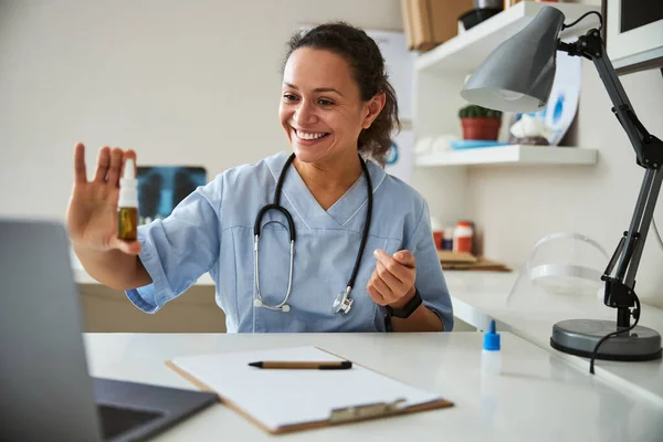 Médico animado manteniendo una botella de aerosol nasal — Foto de Stock