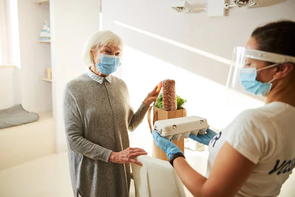 Cuidador que suministra alimentos a una persona mayor — Foto de Stock