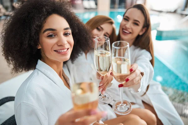 Gyönyörű nő és két barátnője pezsgős poharakkal a kezében. — Stock Fotó
